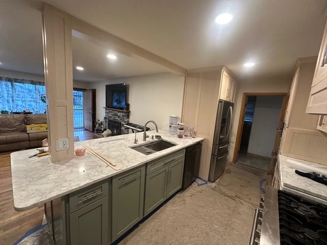 Marble waterfall counter over green lower cabinets
