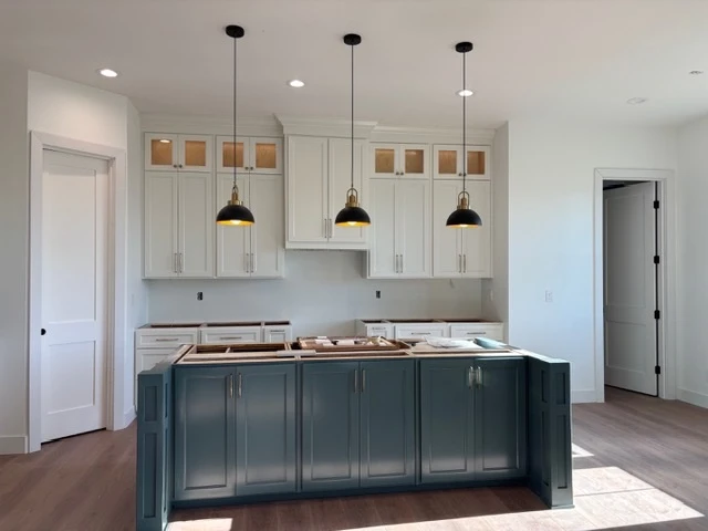 White uppers and a navy island lit by three pendants