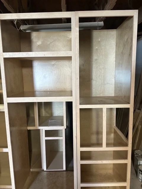 Tall cabinet carcasses standing assembled in the shop