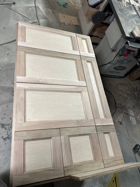 Raw cabinet doors laid out before finishing